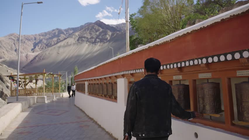4K footage featuring a man moving slowly through a mountaintop monastery, with panoramic views of Ladakh’s rugged landscapes.