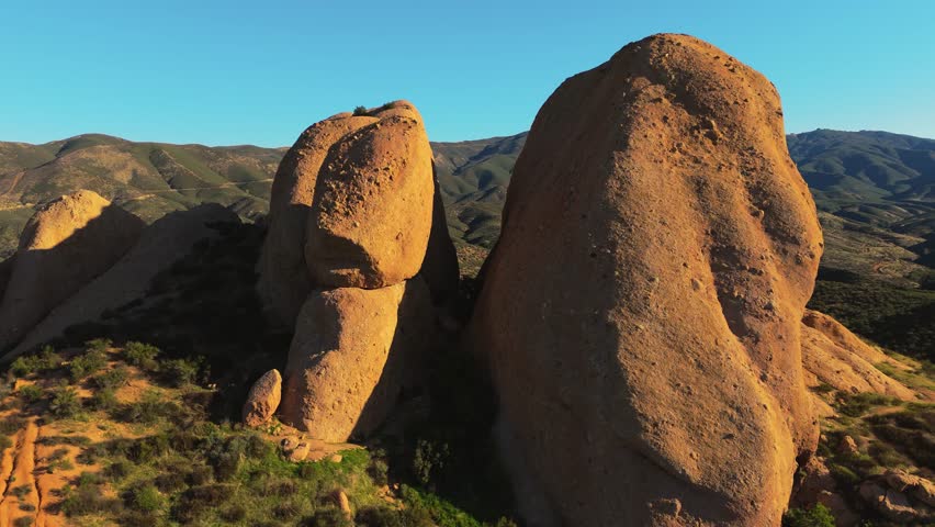 Cinematic 4K aerial footage of rugged rock formations and dry terrain in Southern California, captured in natural light from above.