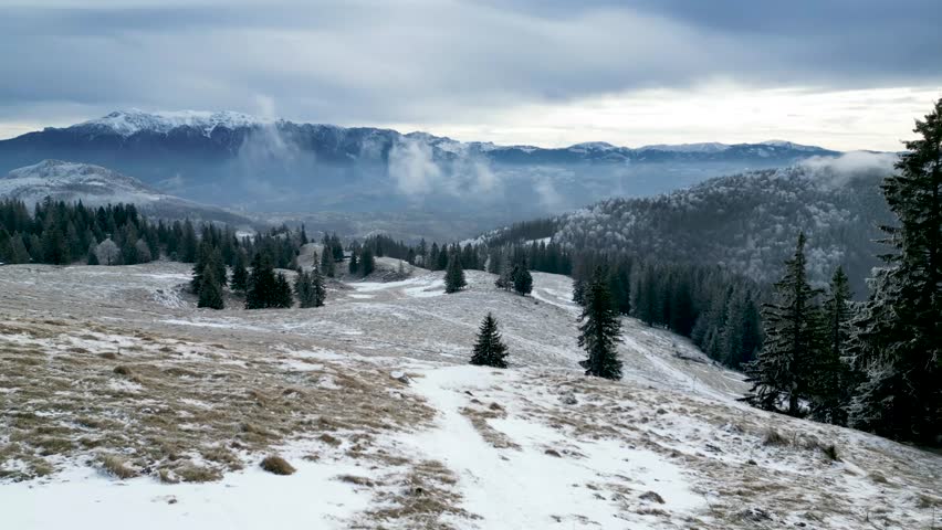A drone view of scenery of snow-covered Mountains landscape in Romania