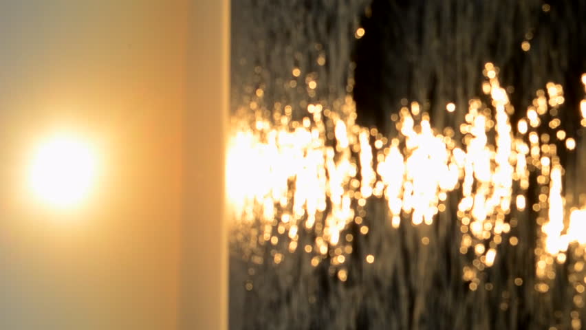 Beautiful sunrise or sunset at sea. Sea sundown dawn. Brightly shining sun in sky, sea and sandy beach. Sunny path on the surface of sea waves. Natural blurred background. Seascape landscape. Vertical