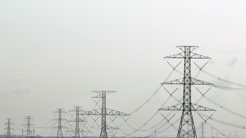 A detailed view of a high-voltage power tower standing tall with several cables hanging, an essential component in transmitting electricity across regions.
