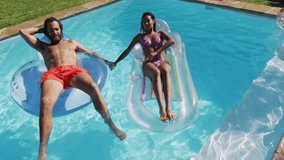 Man and woman relaxing on pool floats with START text animation overlay. Vacation, leisure, relaxation, floating, swimming pool, summer - Powered by Shutterstock - Get 15% off with code: PIKWIZARD15