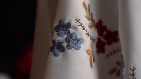 Exploring intricate hand-embroidered textile designs with floral patterns in a cozy indoor setting. Traditional Ukrainian Embroidery - Powered by Shutterstock - Get 15% off with code: PIKWIZARD15