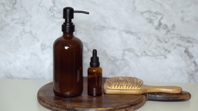  Amber glass shampoo and serum bottles with bamboo hairbrush on dark wood board and marble background. Minimalist flat lay showcasing natural, eco-friendly beauty and sustainable haircare. - Powered by Shutterstock - Get 15% off with code: PIKWIZARD15