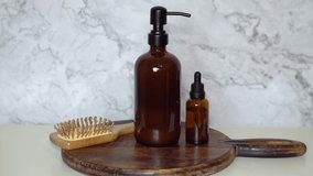  Amber glass shampoo and serum bottles with bamboo hairbrush on dark wood board and marble background. Minimalist flat lay showcasing natural, eco-friendly beauty and sustainable haircare. - Powered by Shutterstock - Get 15% off with code: PIKWIZARD15