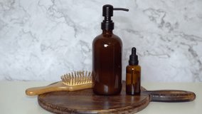  Amber glass shampoo and serum bottles with bamboo hairbrush on dark wood board and marble background. Minimalist flat lay showcasing natural, eco-friendly beauty and sustainable haircare. - Powered by Shutterstock - Get 15% off with code: PIKWIZARD15