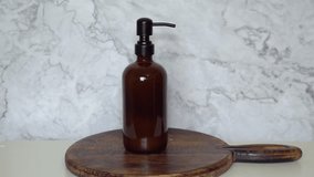 Amber glass shampoo bottle on dark wooden board and marble background. Minimalist natural beauty flat lay with eco-friendly packaging and organic haircare product styling. - Powered by Shutterstock - Get 15% off with code: PIKWIZARD15