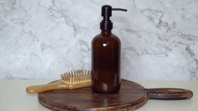 Amber glass shampoo bottle with bamboo hairbrush on dark wooden board and marble background. Minimalist natural, eco-friendly haircare and sustainable beauty product styling. - Powered by Shutterstock - Get 15% off with code: PIKWIZARD15