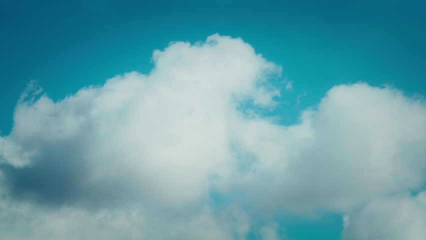 Static cinematic shot capturing white clouds slowly moving through a clear sunny blue sky