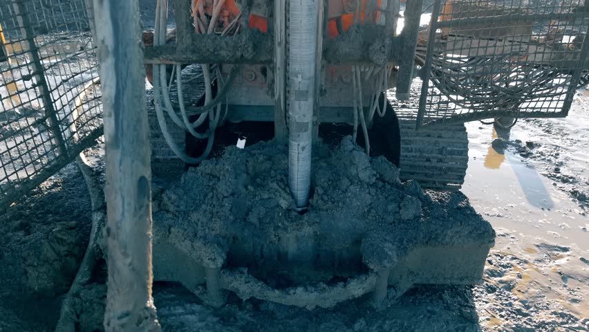 Construction equipment piling rig drill performing soil exploration in muddy area