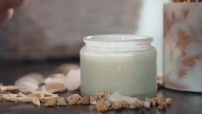 Close up of hand with polished nails lighting white candle with matchstick, flame catching wick surrounded by seashells and starfish on dark marble surface in cozy calm decorative setting - Powered by Shutterstock - Get 15% off with code: PIKWIZARD15