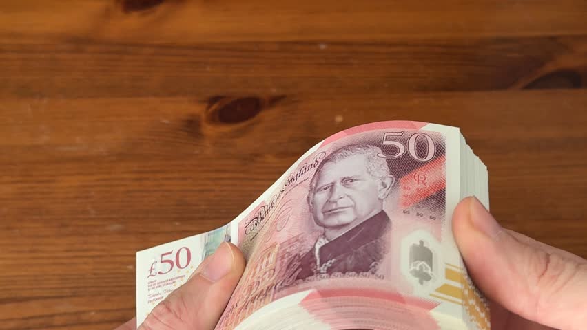 Slow motion flick through stack of King Charles and Queen Elizabeth £50 notes