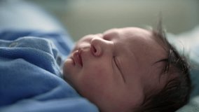 Serene newborn baby sleeping in a blue onesie, swaddled in soft blankets in a hospital bed, focus on the baby's peaceful expression, capturing the tranquility of newborn life - Powered by Shutterstock - Get 15% off with code: PIKWIZARD15