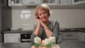 Professional baker smiles warmly while admiring beautifully decorated cupcakes placed near candle, gently removes hands with satisfaction and blows out candle celebrating creative baking success - Powered by Shutterstock - Get 15% off with code: PIKWIZARD15