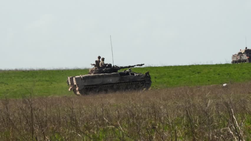 close-up of a commander and gunner directing a British army Warrior FV510 IFV, in action on a military exercise