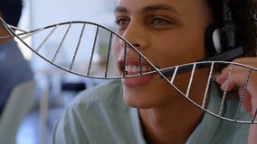 DNA strand animation over person wearing headset in office setting. Biotechnology, innovation, research, virtual reality, genetics, technology - Powered by Shutterstock - Get 15% off with code: PIKWIZARD15