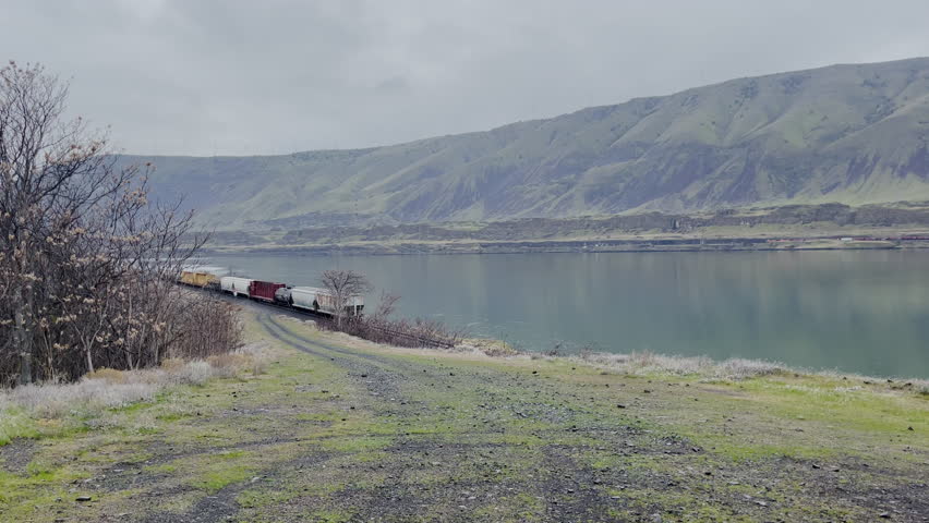 A train going through the Columbia River Gorge, shot from Oregon Side. Panning shot showing the Washington Side.