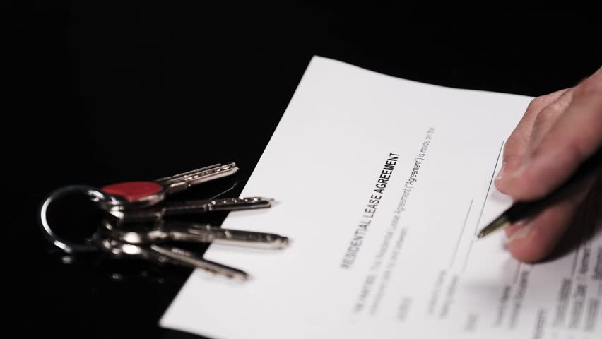 Signing a residential rental agreement with keys and cash – real estate and tenancy concept