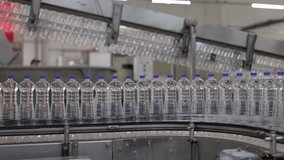 Water bottles on a conveyor belt in a factory. This automated production line shows the manufacturing of plastic bottles. - Powered by Shutterstock - Get 15% off with code: PIKWIZARD15
