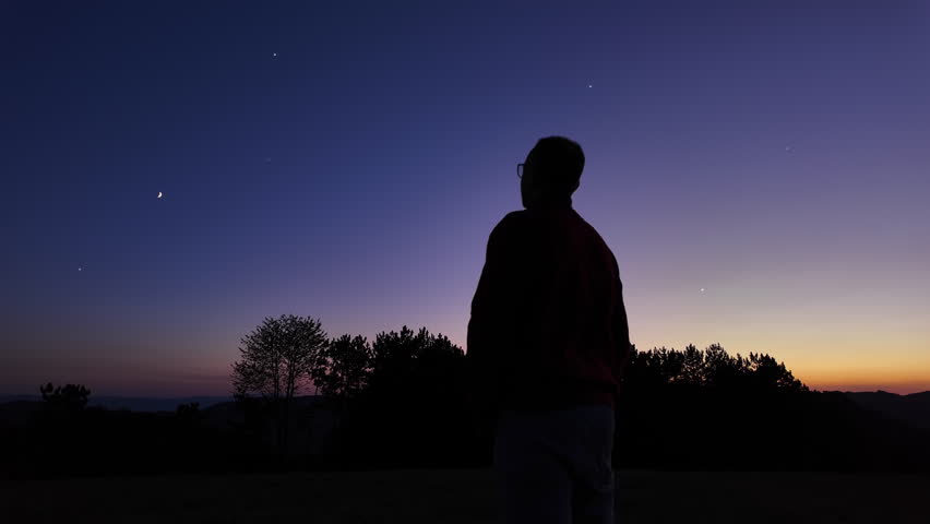 Silhouette of a man and countryside under the stars and Moonlight.