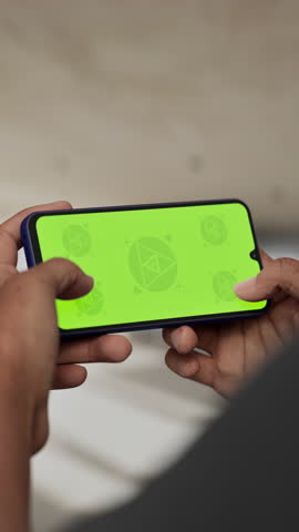 GREEN SCREEN CHROMA KEY A hand holding a smartphone with a green screen inside a renovated apartment