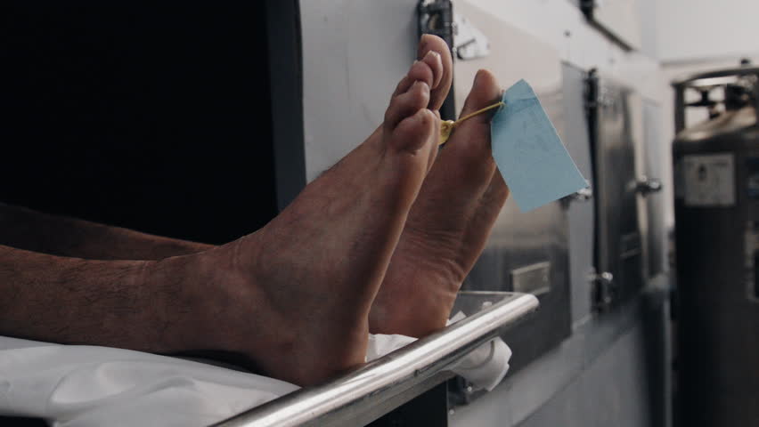Feet in morgue cooler close up side profile