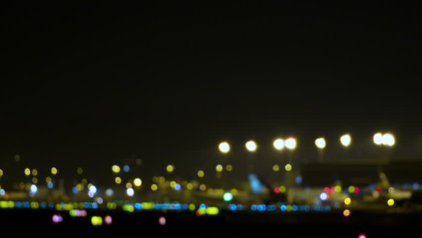 Blurred airport lights generating mesmerizing bokeh effect, revealing nocturnal aviation landscape with vibrant illumination and dynamic urban atmosphere