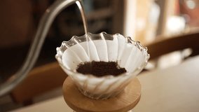 Preparation of filter coffee using the pour-over method with a v60 dripper, hot water is poured over ground coffee beans placed on a paper filter, extracting the coffee's flavor and aroma - Powered by Shutterstock - Get 15% off with code: PIKWIZARD15