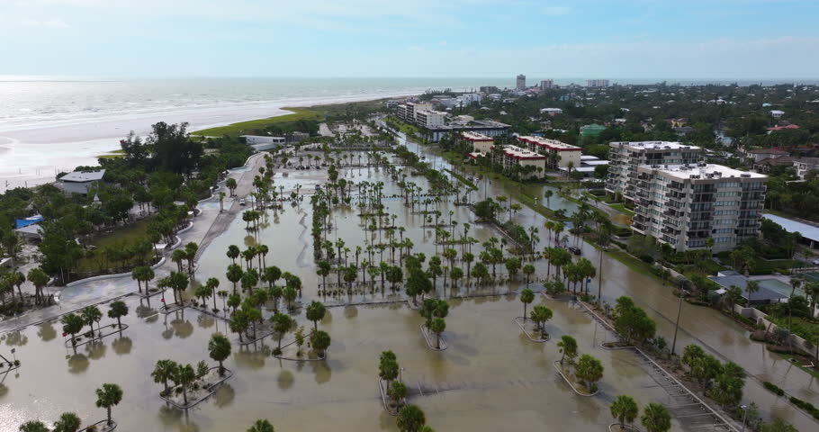 Flooded parking lot from hurricane Milton storm surge at Siesta Key in Sarasota, Florida. Aftermath of natural disaster in USA south.