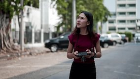 Focused young asian female photographer standing on quiet city street, holding digital camera and capturing urban scene during daytime travel shoot - Powered by Shutterstock - Get 15% off with code: PIKWIZARD15