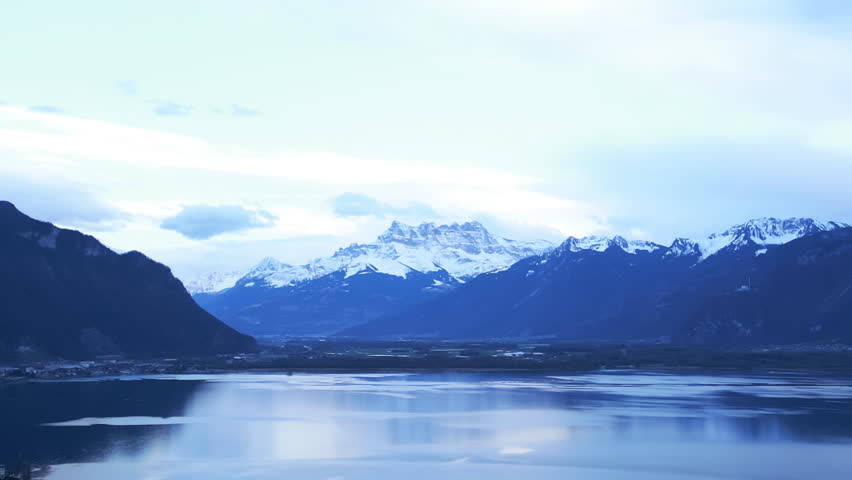 Aerial: Dents du Midi and Lake Geneva at sunset in Montreux, canton of Vaud, Switzerland, establishing drone shot