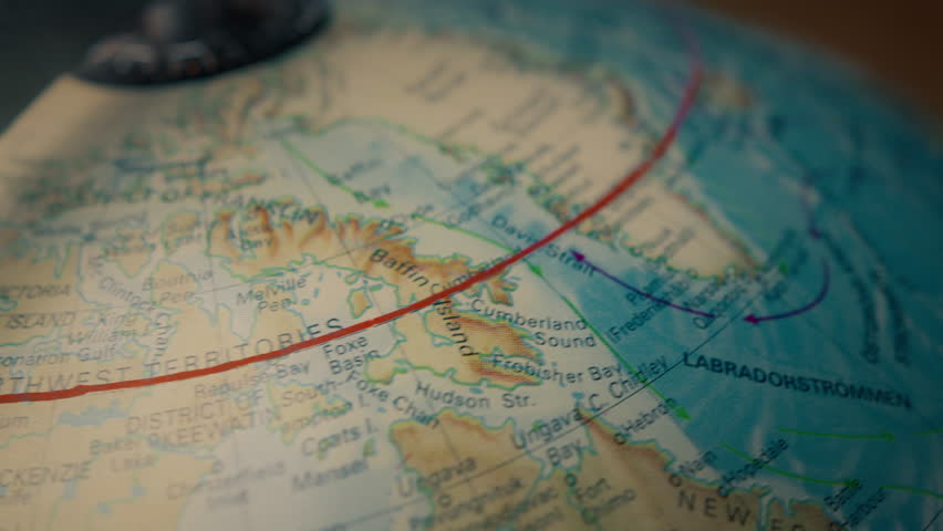 Close up of a globe map slowly rotating west, following the arctic circle above Canada, Greenland, Iceland and Scandinavia. 4K