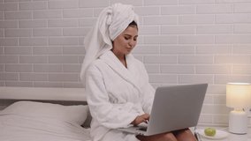 Laptop work, Work-from-home, Room environment. In bathrobe and in solitude of bedroom, woman is busy working on laptop. - Powered by Shutterstock - Get 15% off with code: PIKWIZARD15