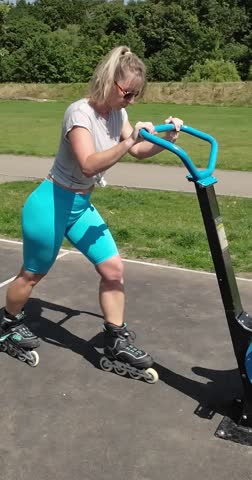 young girl doing fitness in the park during  sunny day using exercise bike and roller skates |  vertical Video 4K