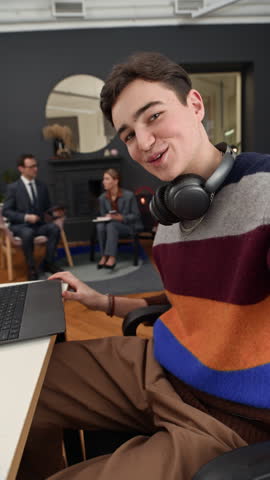 Vertical POV of gen Z male intern talking on camera while vlogging on first office day