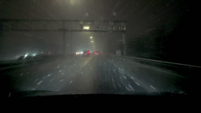 A challenging night drive occurs amid heavy snowfall conditions, featuring low visibility and snowy roads