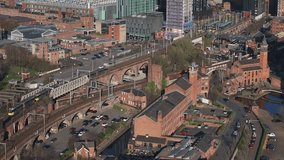 Aerial view of Manchester, UK, showing trains on tracks, canals, red brick buildings, modern high rises, and historic architecture in motion. - Powered by Shutterstock - Get 15% off with code: PIKWIZARD15