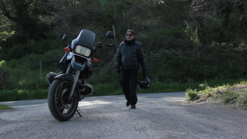 Biker gets on a motorcycle