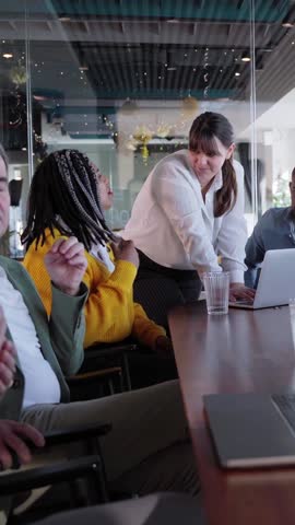 Multiracial group of business people working together using laptop at office during brainstorming, concept of a marketing strategy company. Vertical video with copy space.