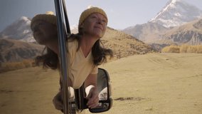 Woman traveler leans out of window of motorhome looking out over captivating mountain landscape - Powered by Shutterstock - Get 15% off with code: PIKWIZARD15