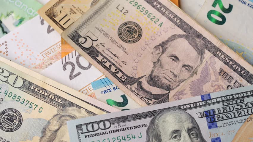 Coins fall on banknotes of different currencies and denominations