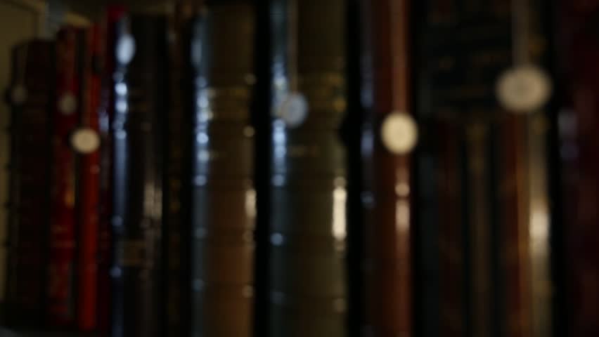 This video showcases a collection of antique books neatly arranged on a library shelf. The leather-bound volumes exude history and knowledge, perfect for vintage themes.