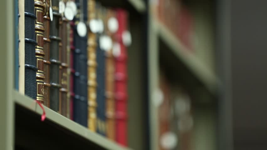 This video showcases a collection of antique books neatly arranged on a library shelf. The leather-bound volumes exude history and knowledge, perfect for vintage themes.