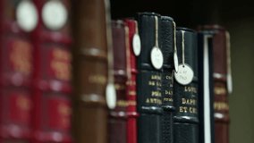 This video showcases a collection of antique books neatly arranged on a library shelf. The leather-bound volumes exude history and knowledge, perfect for vintage themes. - Powered by Shutterstock - Get 15% off with code: PIKWIZARD15