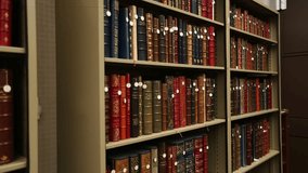 This video showcases a collection of antique books neatly arranged on a library shelf. The leather-bound volumes exude history and knowledge, perfect for vintage themes. - Powered by Shutterstock - Get 15% off with code: PIKWIZARD15