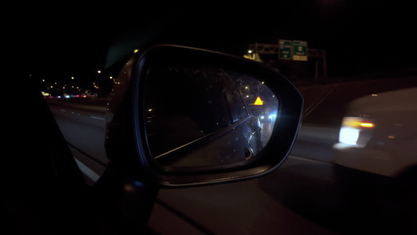 Car mirror at Driving in on the night road with light. Side shot