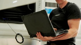 Technician checking truck systems with modern diagnostic software in repair shop. - Powered by Shutterstock - Get 15% off with code: PIKWIZARD15