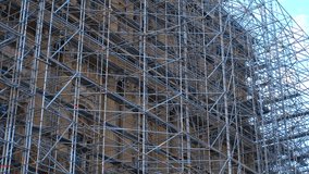 Complex scaffolding structure surrounding a tall building under renovation.Extensive metal scaffolding envelops a high-rise building. Structural complexity highlights the construction process - Powered by Shutterstock - Get 15% off with code: PIKWIZARD15