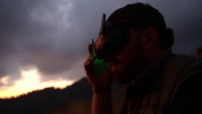 young adult adjusting fpv drone goggles outdoors while talking and giving instructions, explorer or traveler using vr virtual reality headset in nature at sunset - Powered by Shutterstock - Get 15% off with code: PIKWIZARD15