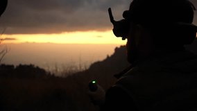 silhouette of a young man flying a fpv drone in nature using goggles headset vr headset in the mountain - Powered by Shutterstock - Get 15% off with code: PIKWIZARD15